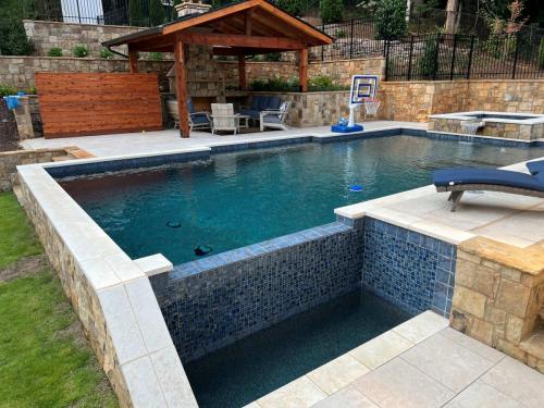 Travstone decking, Limestone Coping, brown flagstone, midnight Blue regular pebble