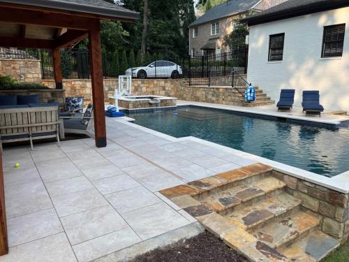 Travstone decking, Limestone Coping, brown flagstone, midnight Blue regular pebble