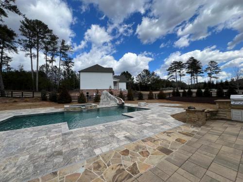 Rectangular pool with spa & slide.Silver travertine Coping and decking