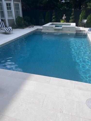 shellbeige limestone coping and decking. Aquacool regular pebble