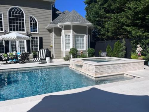 shellbeige limestone coping and decking. Aquacool regular pebble